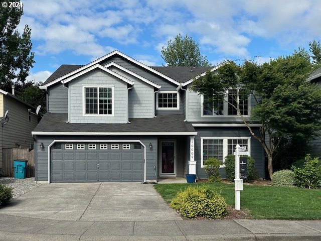 a front view of a house with a yard and garage