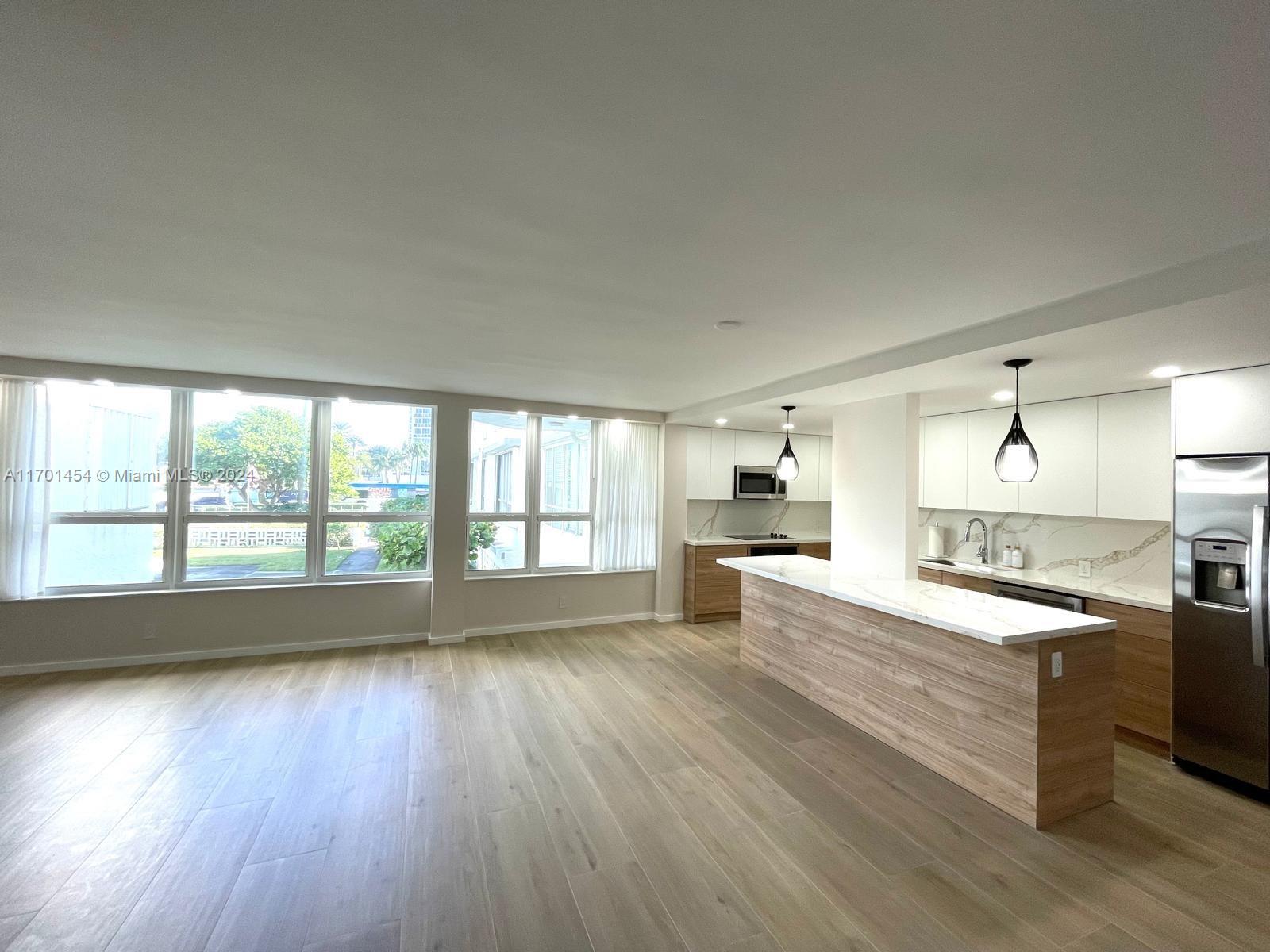 a large kitchen with a large window a sink and appliances