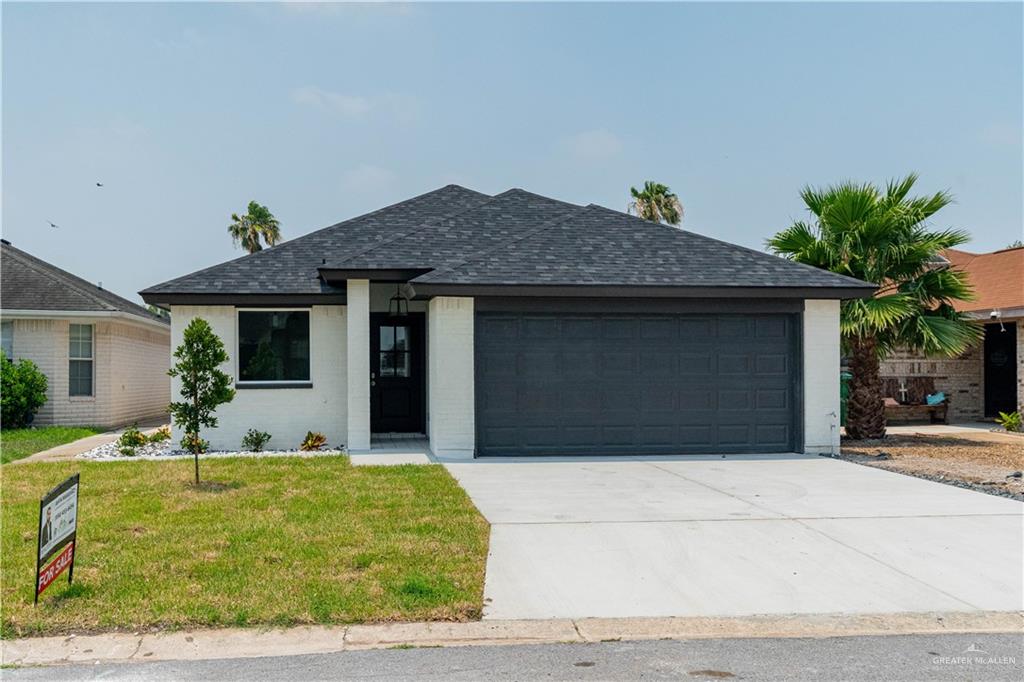 Ranch-style home with a front yard and a garage