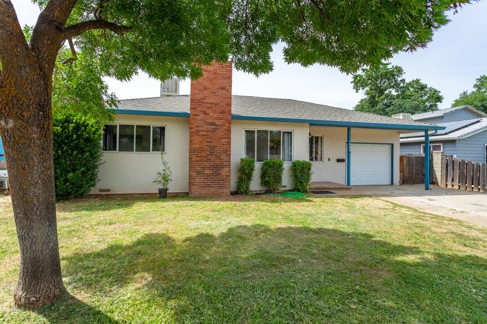 a front view of house with yard and trees around