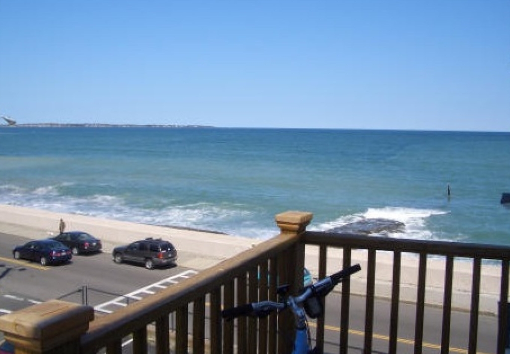 a view of a balcony with wooden floor and lake view