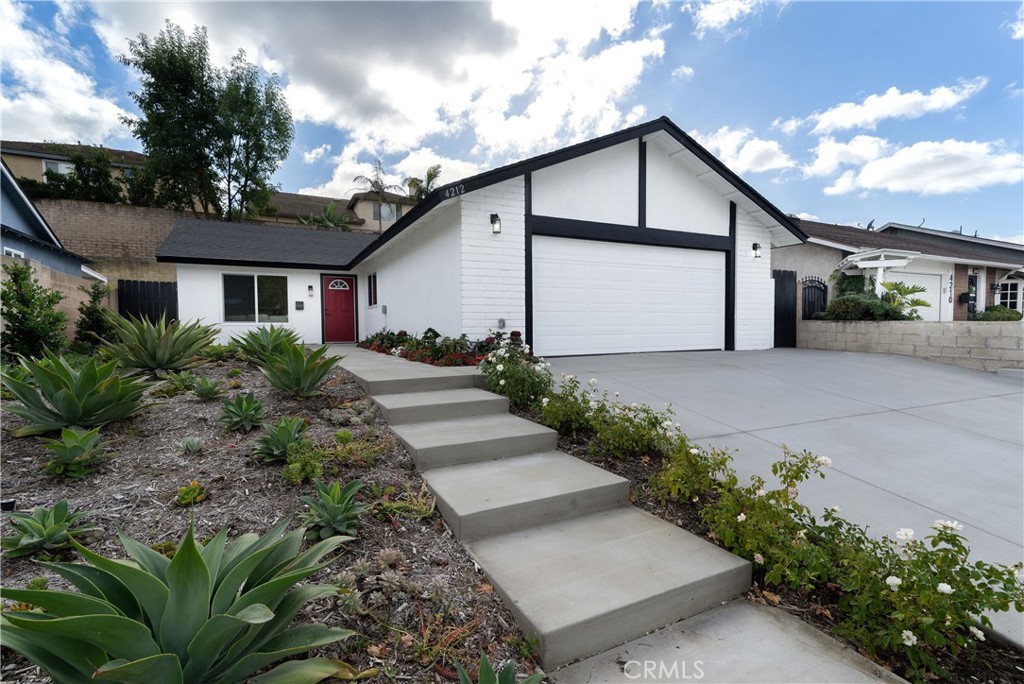 a front view of house with yard and trees around