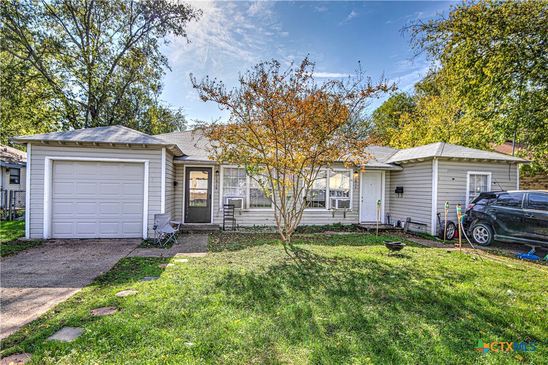 a view of a house with a yard and pathway