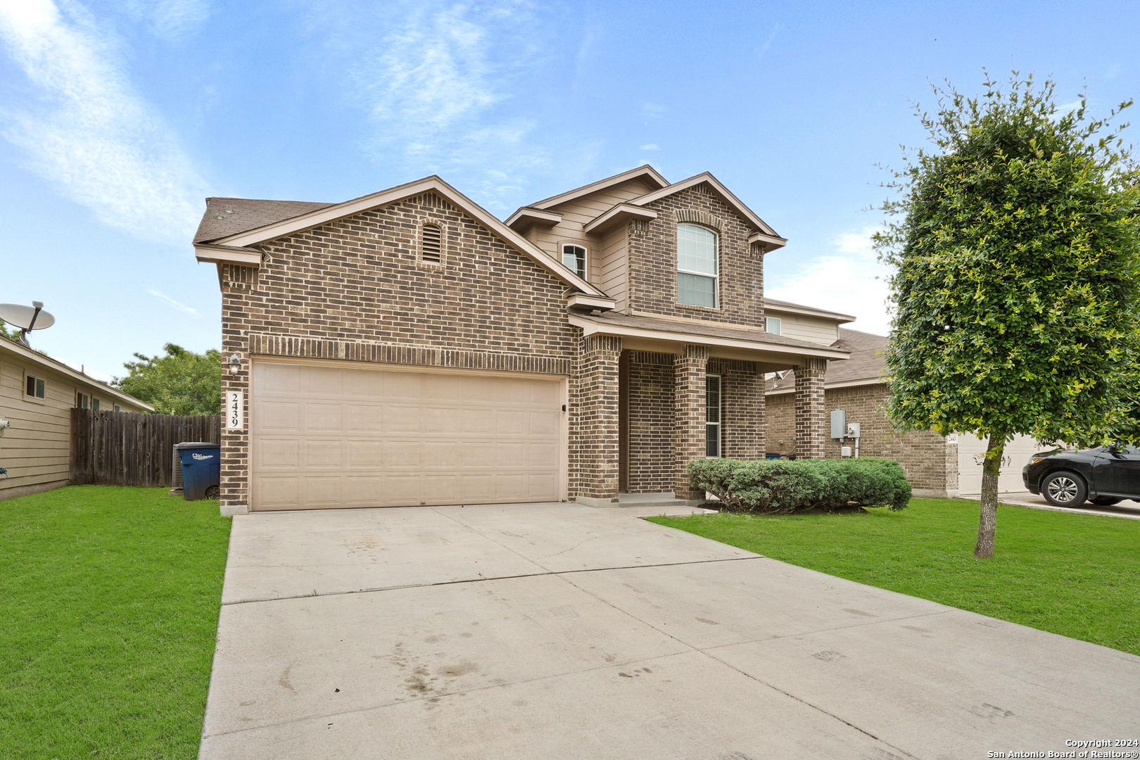 a front view of a house with yard and garage