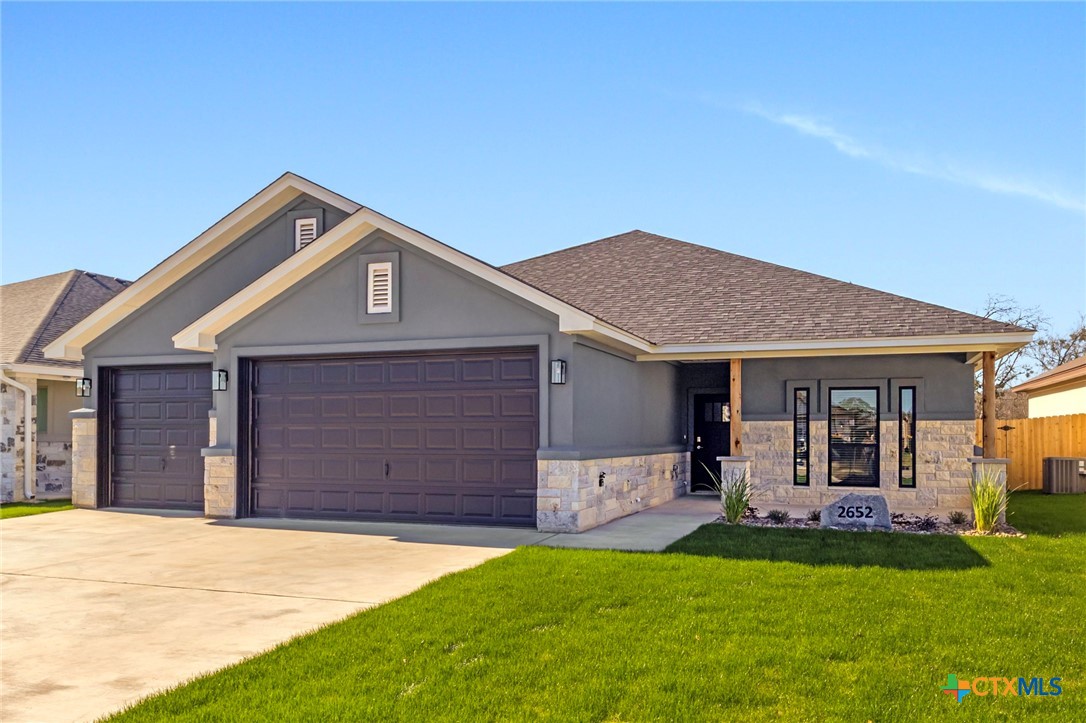 a front view of a house with a yard and garage