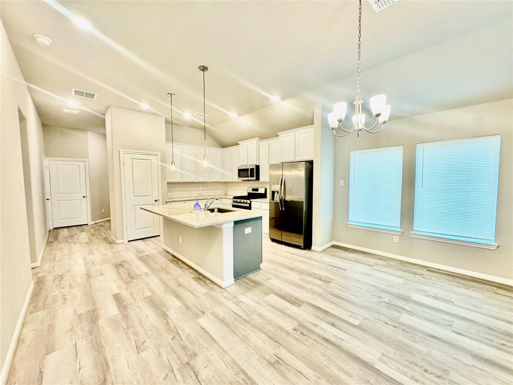 a large kitchen with kitchen island a sink stainless steel appliances and cabinets