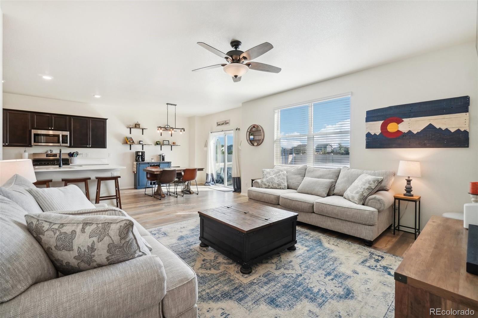 a living room with furniture and a view of kitchen