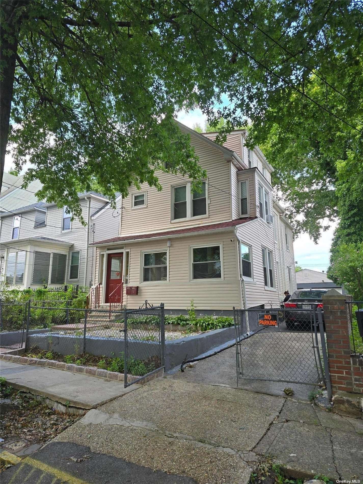 a front view of a house with a tree