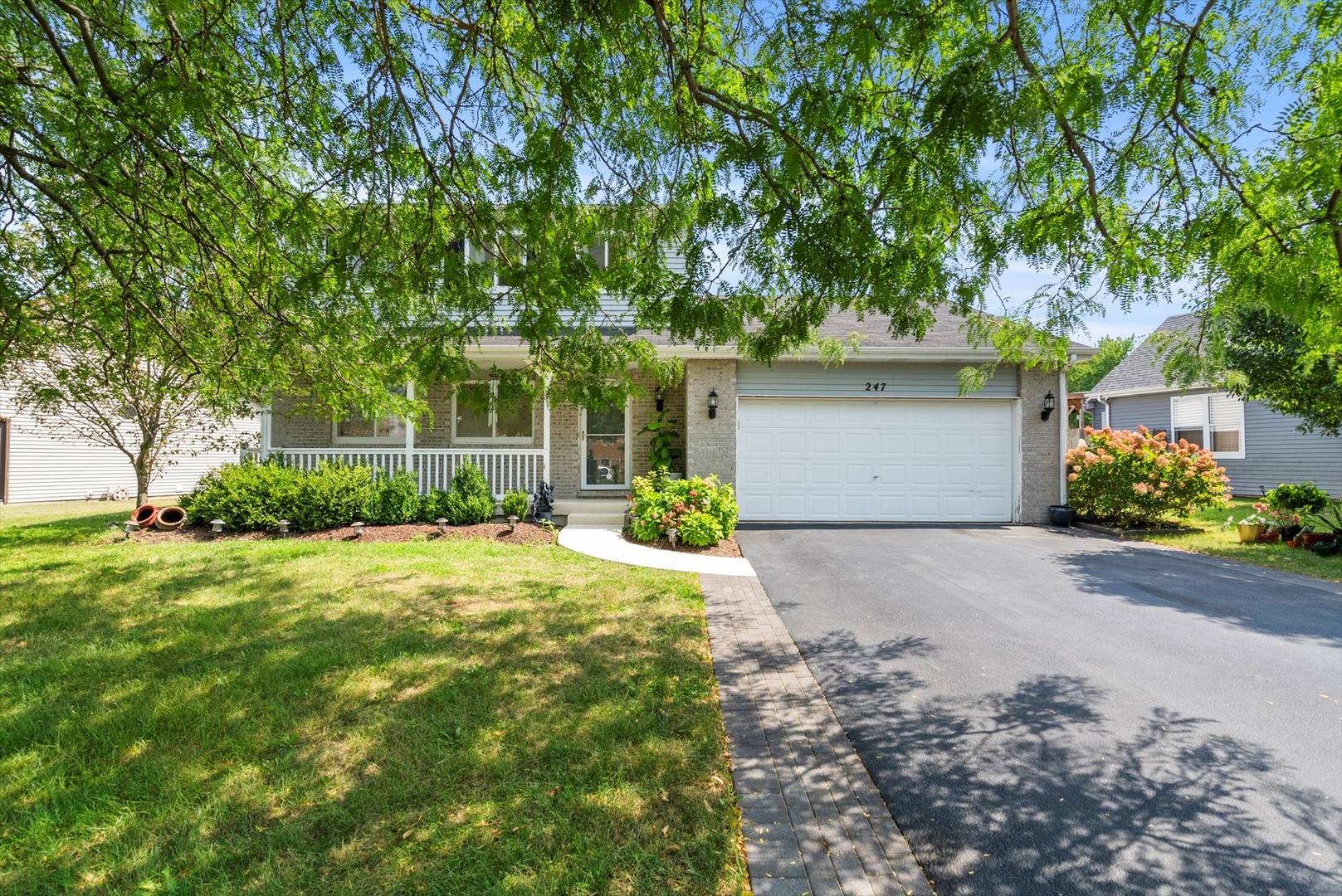 a front view of a house with a yard and a garage