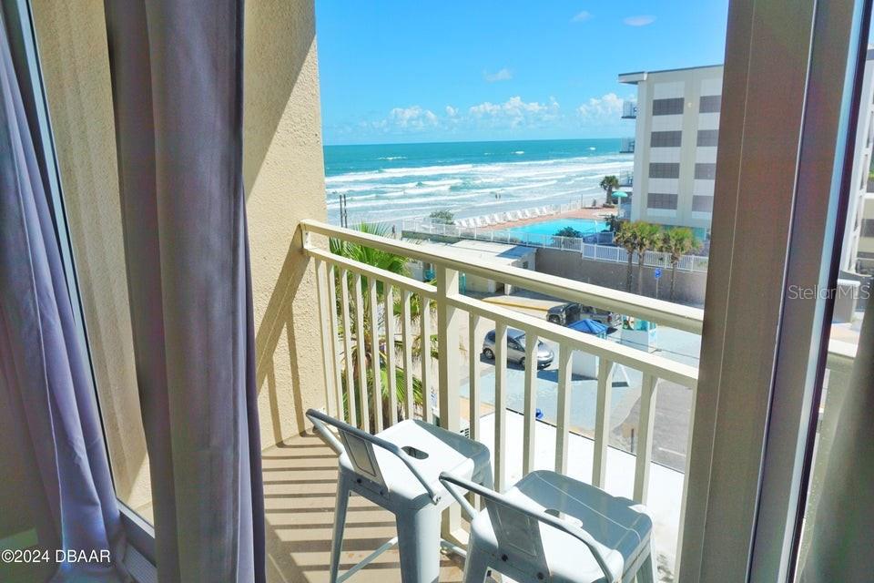 a view of a balcony with chair and floor to ceiling window