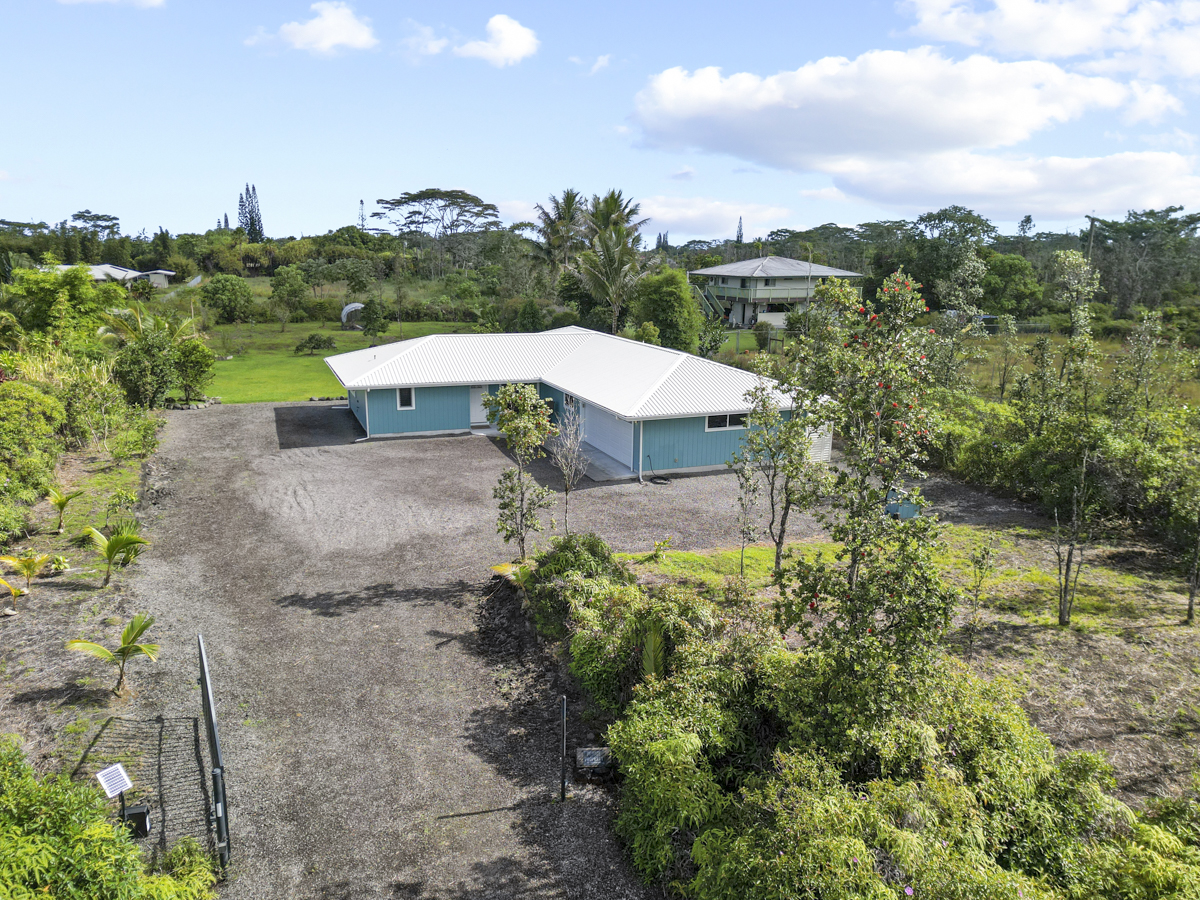 an aerial view of a house with yard and mountain view in back