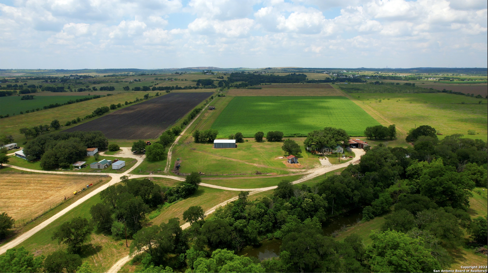 an aerial view of a residential houses with outdoor space and river