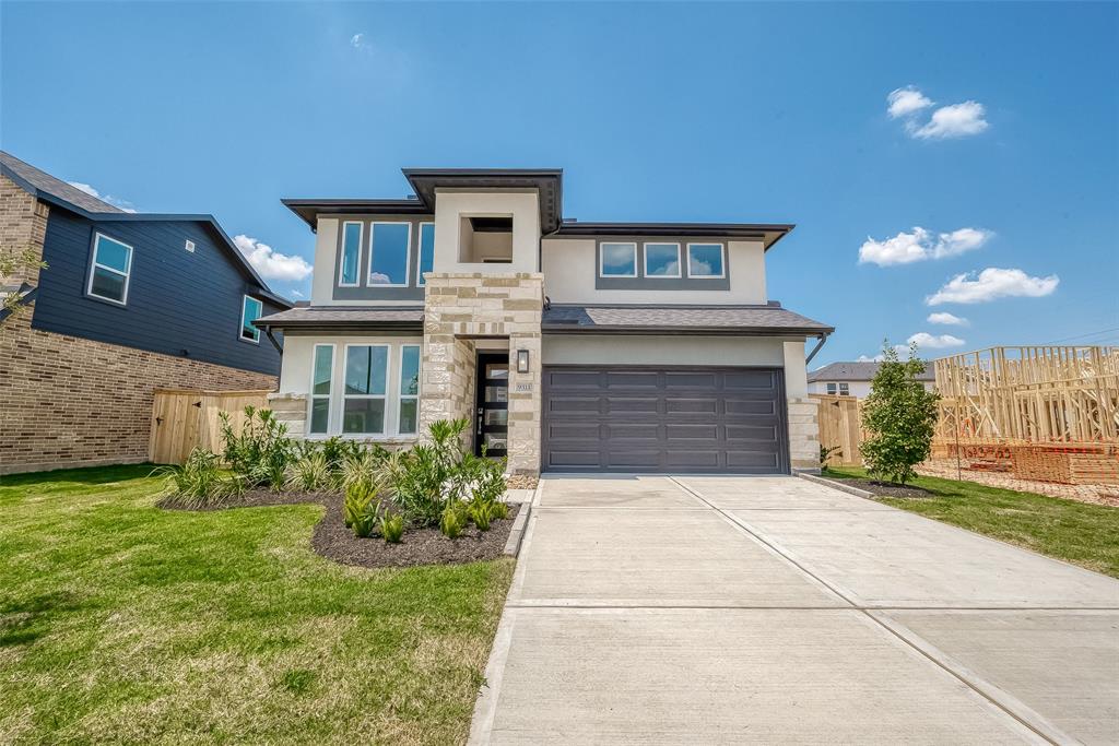 a front view of a house with a yard and garage