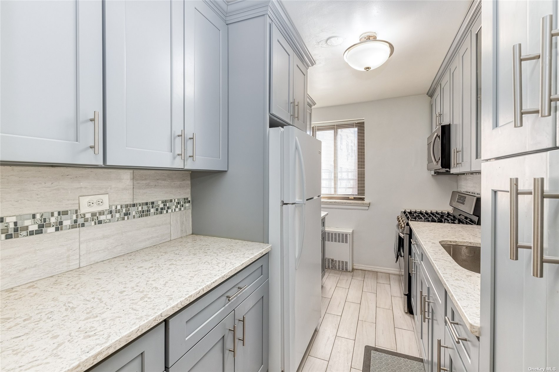 a kitchen with granite countertop a sink a stove and refrigerator