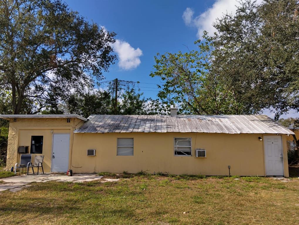 a front view of house with yard and trees in the background