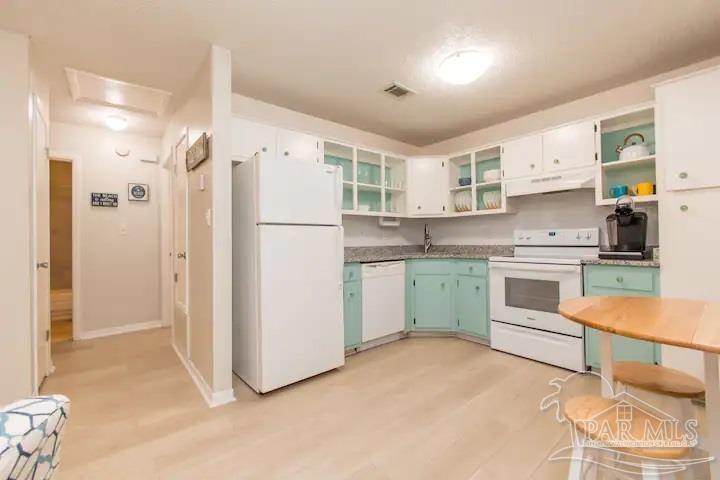 a kitchen with white cabinets and white appliances