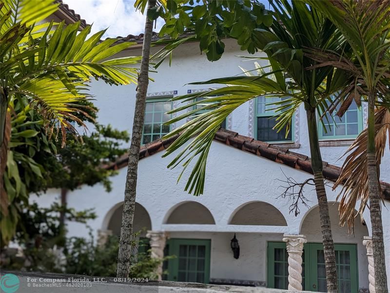 a front view of a house with plants