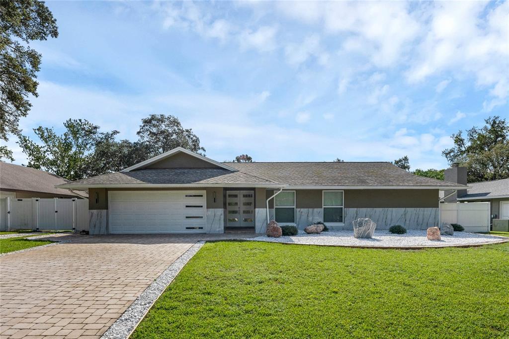 a front view of a house with a garden and outdoor seating