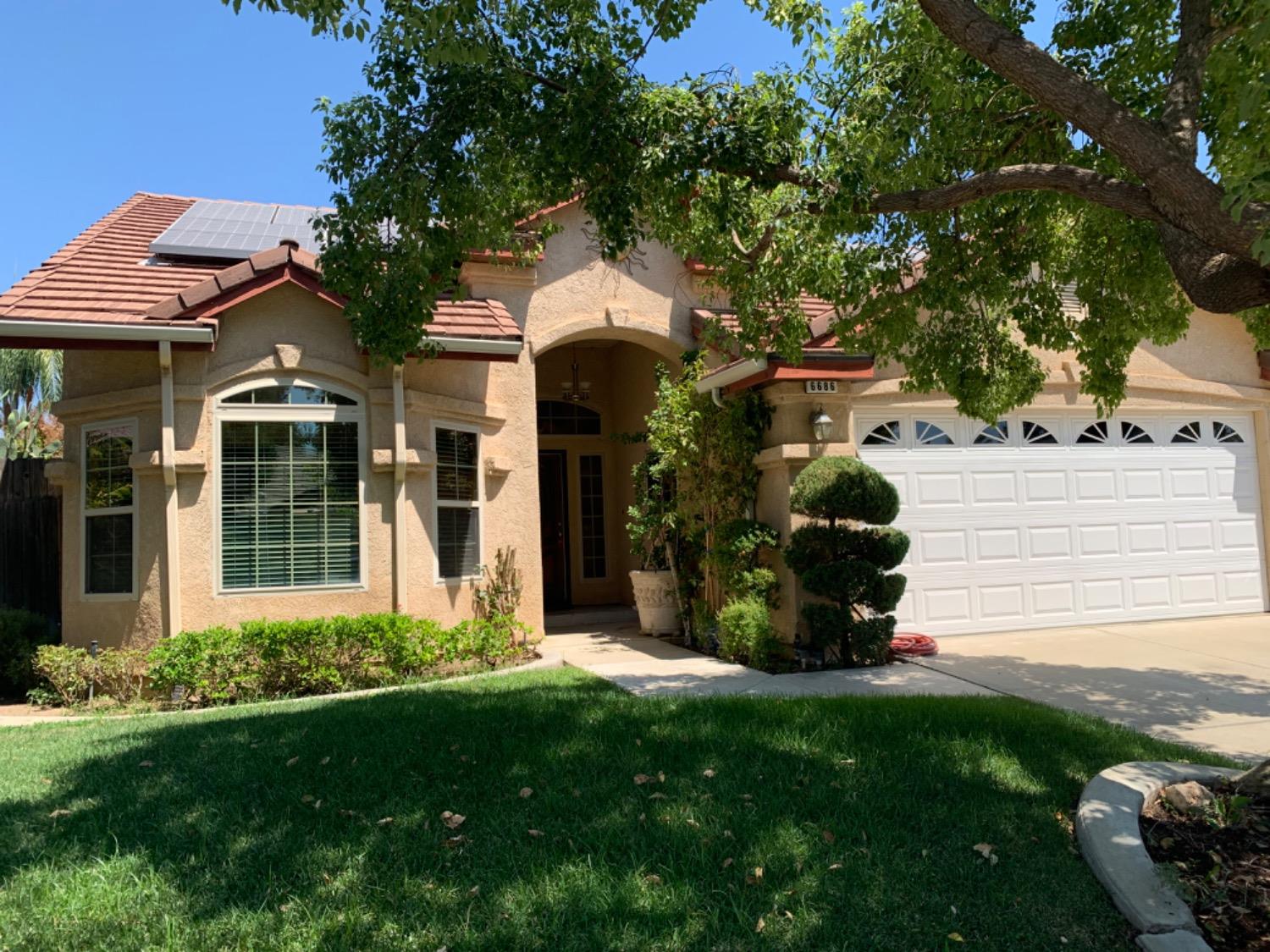 a view of a house with backyard and garden