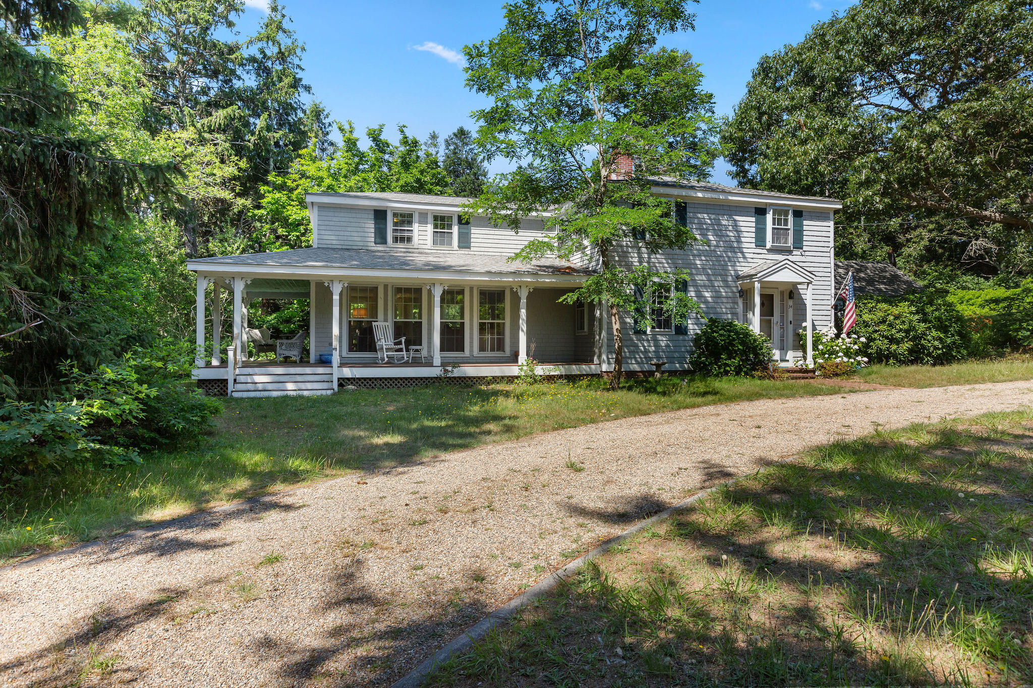 a front view of a house with a yard and potted plants