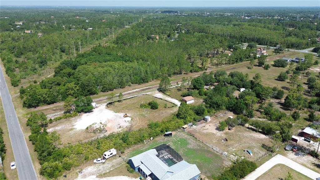 an aerial view of residential houses with outdoor space and trees