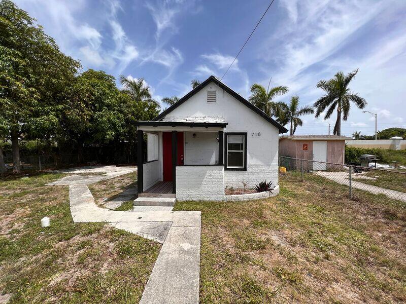 a front view of house with yard and trees in the background