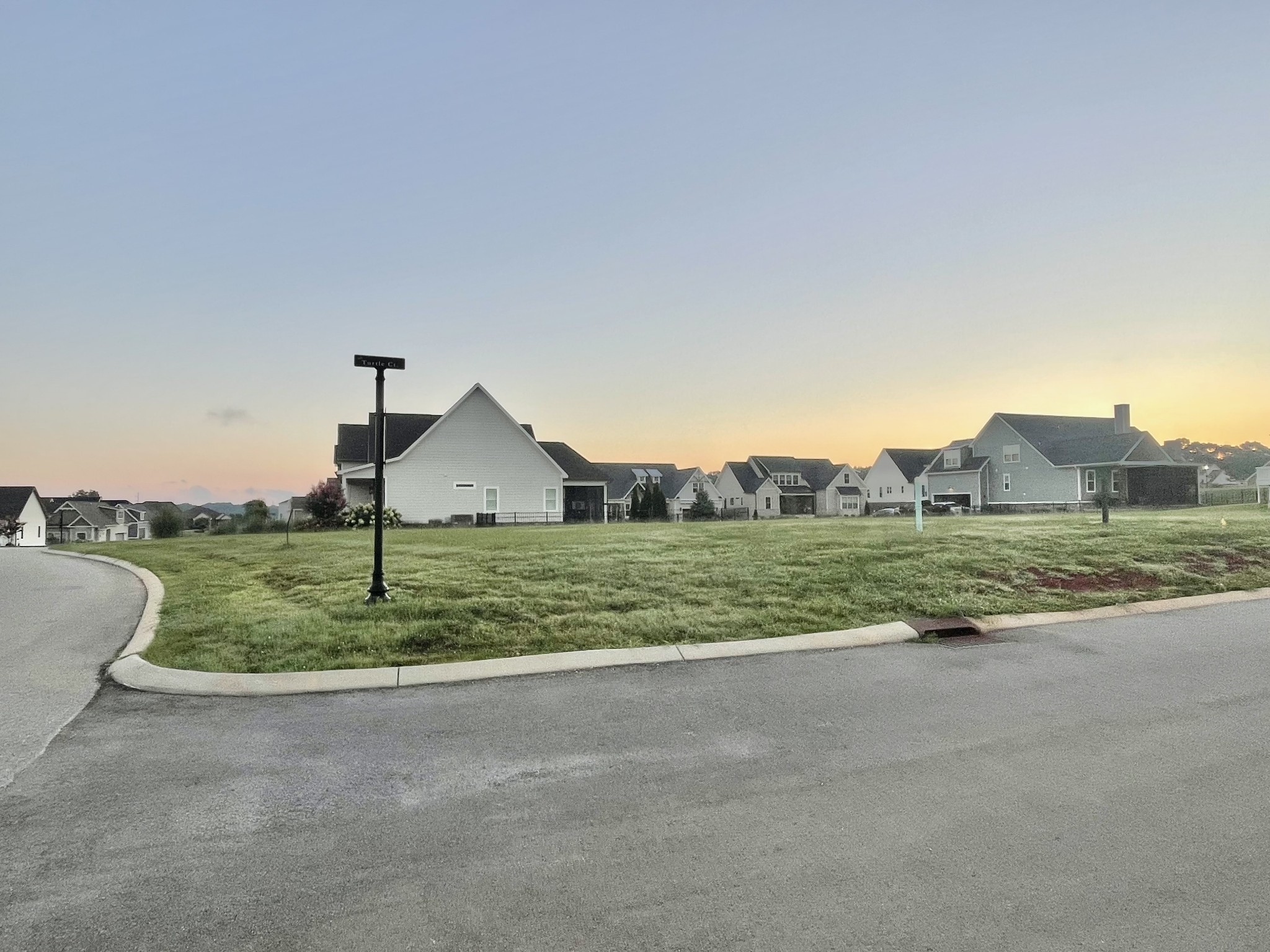 a view of a house with a yard and a large parking space