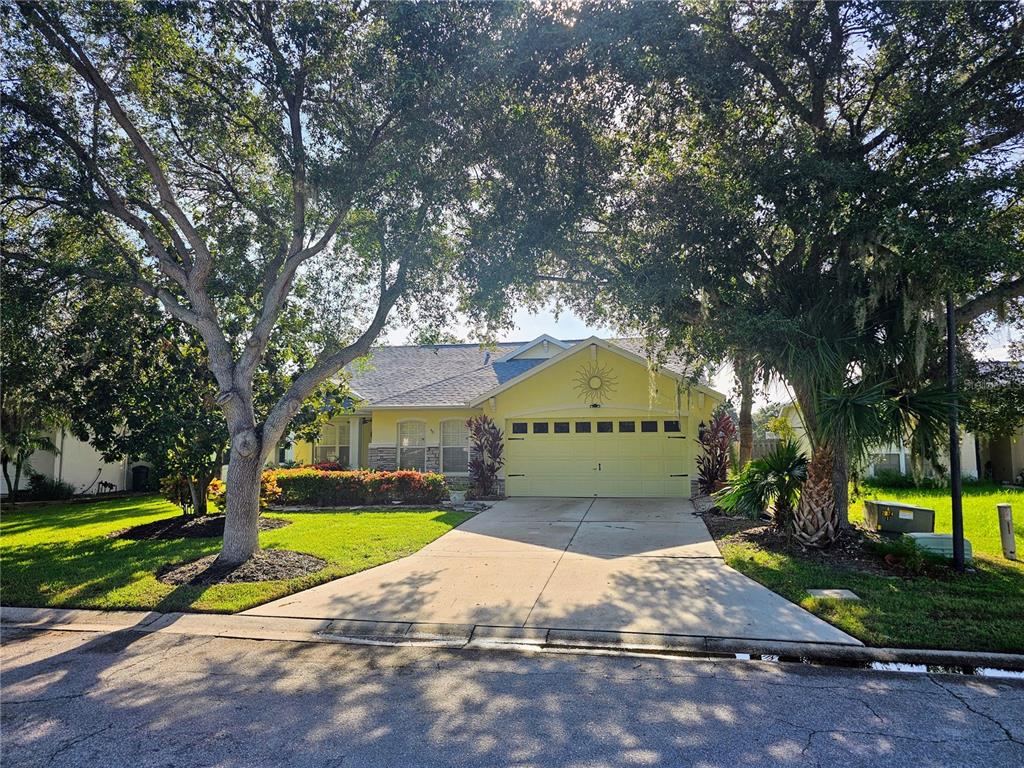 a view of a fountain in front of a house with large trees