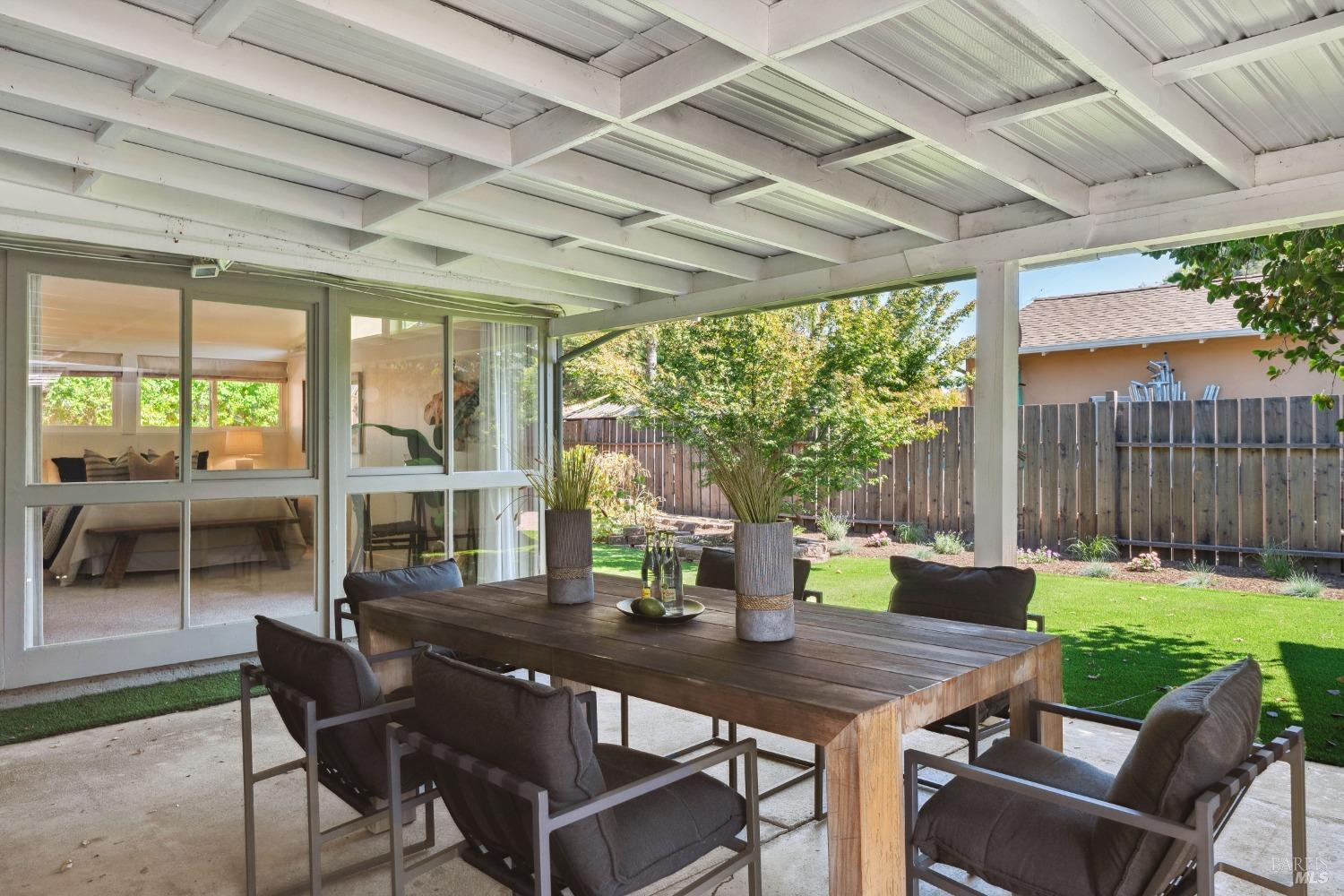 a view of a patio with a table chairs and a backyard