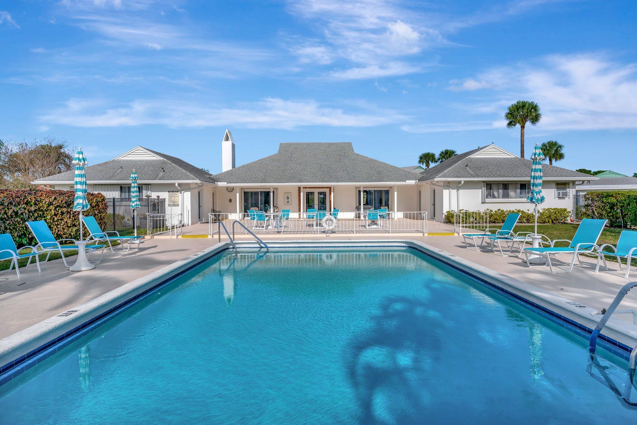 a swimming pool view with a seating space and a garden view