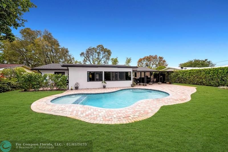 a view of a house with a swimming pool and a yard