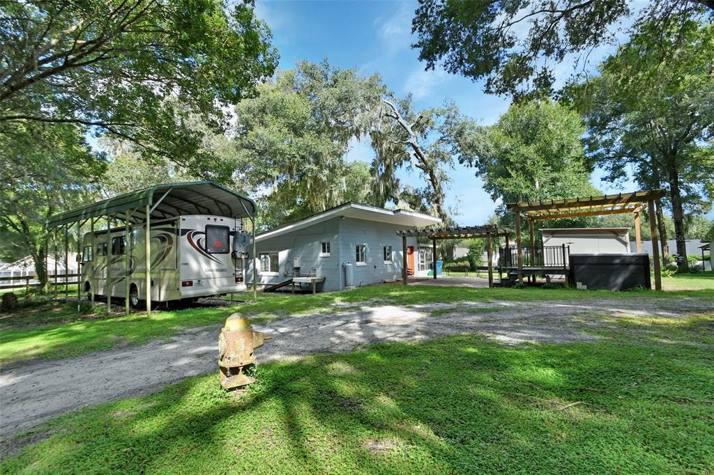 a view of a big house with a big yard and large trees