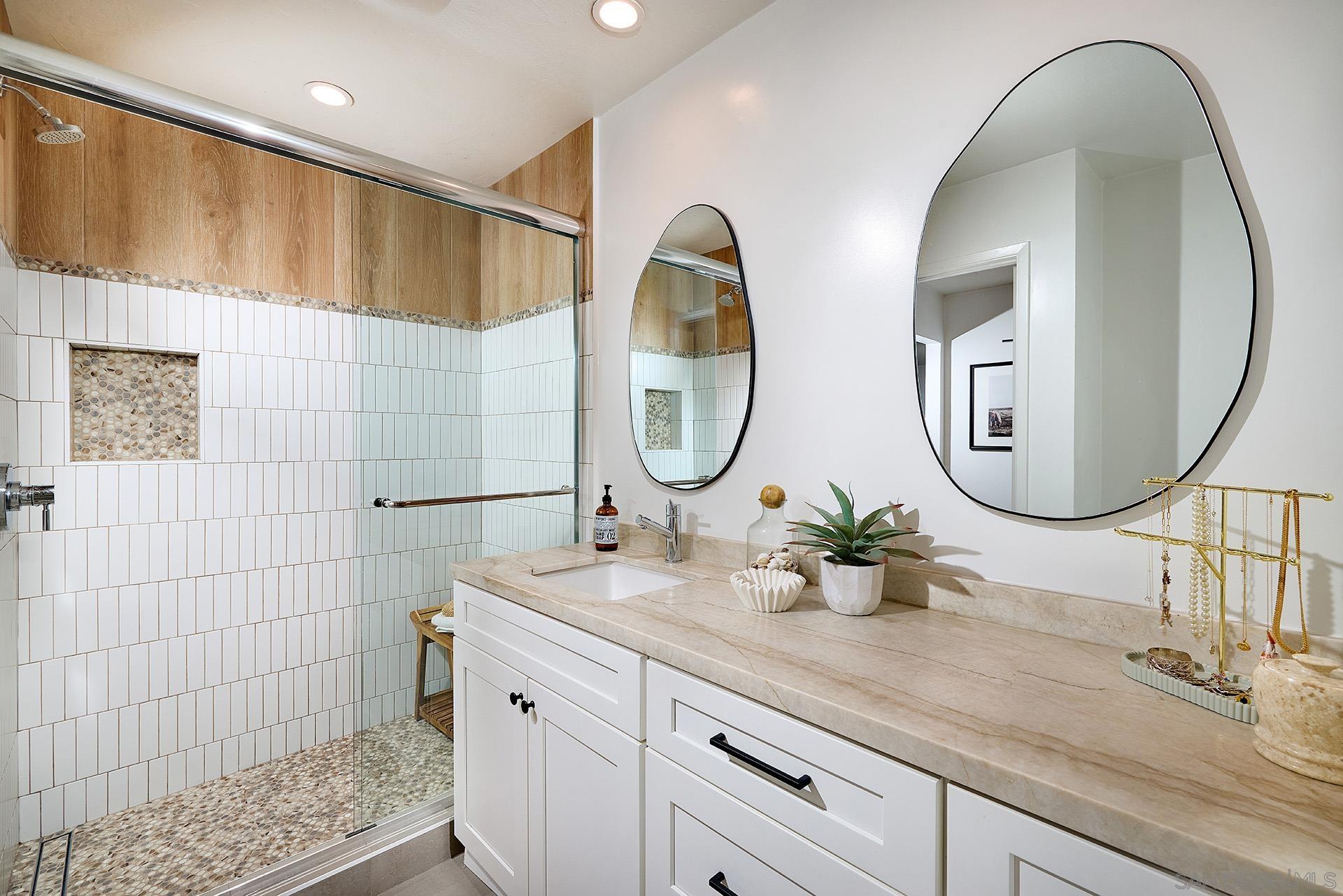 a bathroom with a double vanity sink mirror and shower