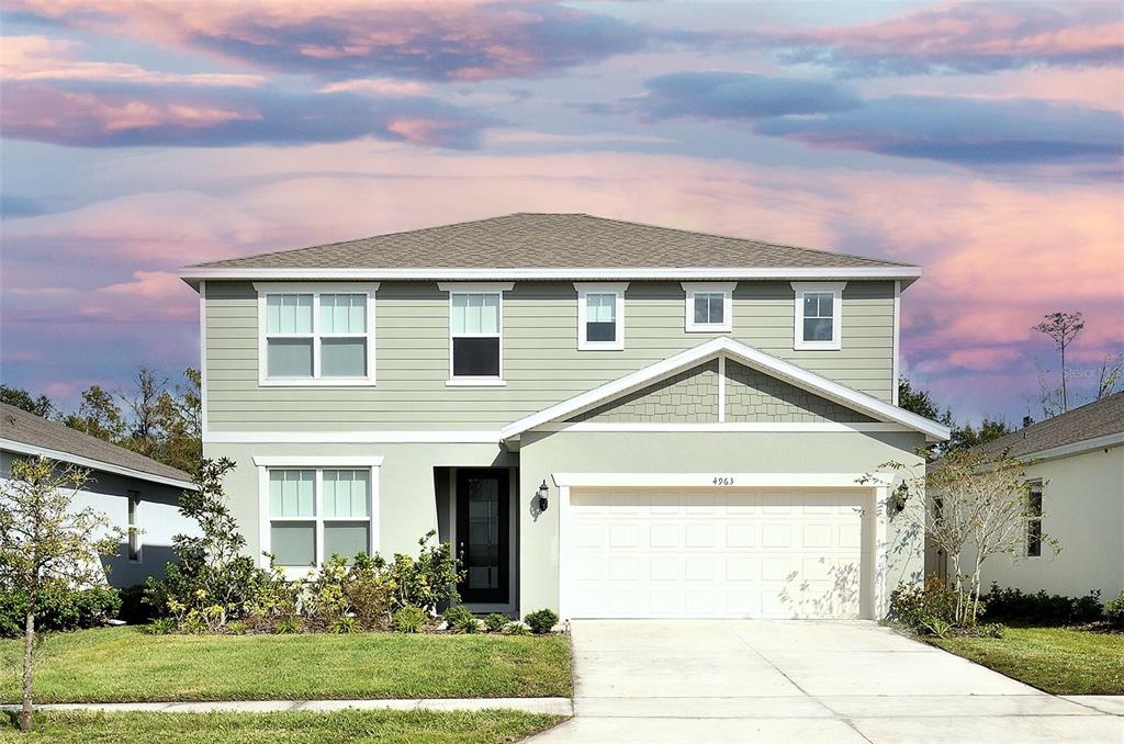 a front view of a house with a yard and garage