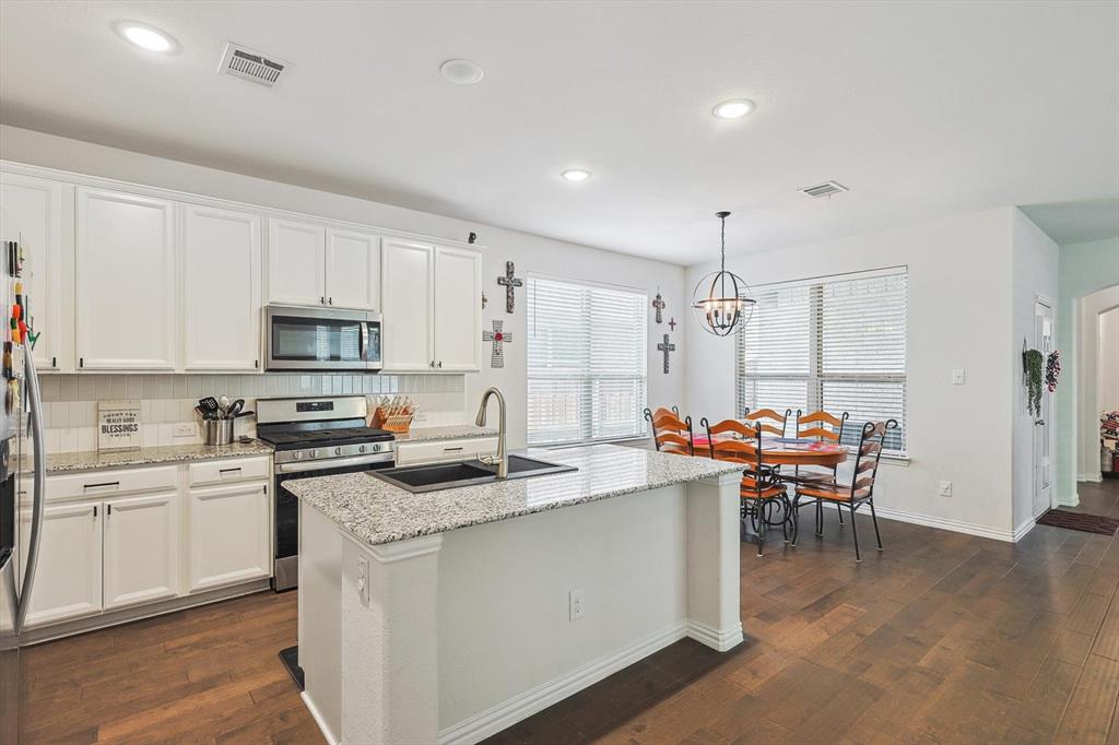 a kitchen that has a lot of cabinets in it and appliances