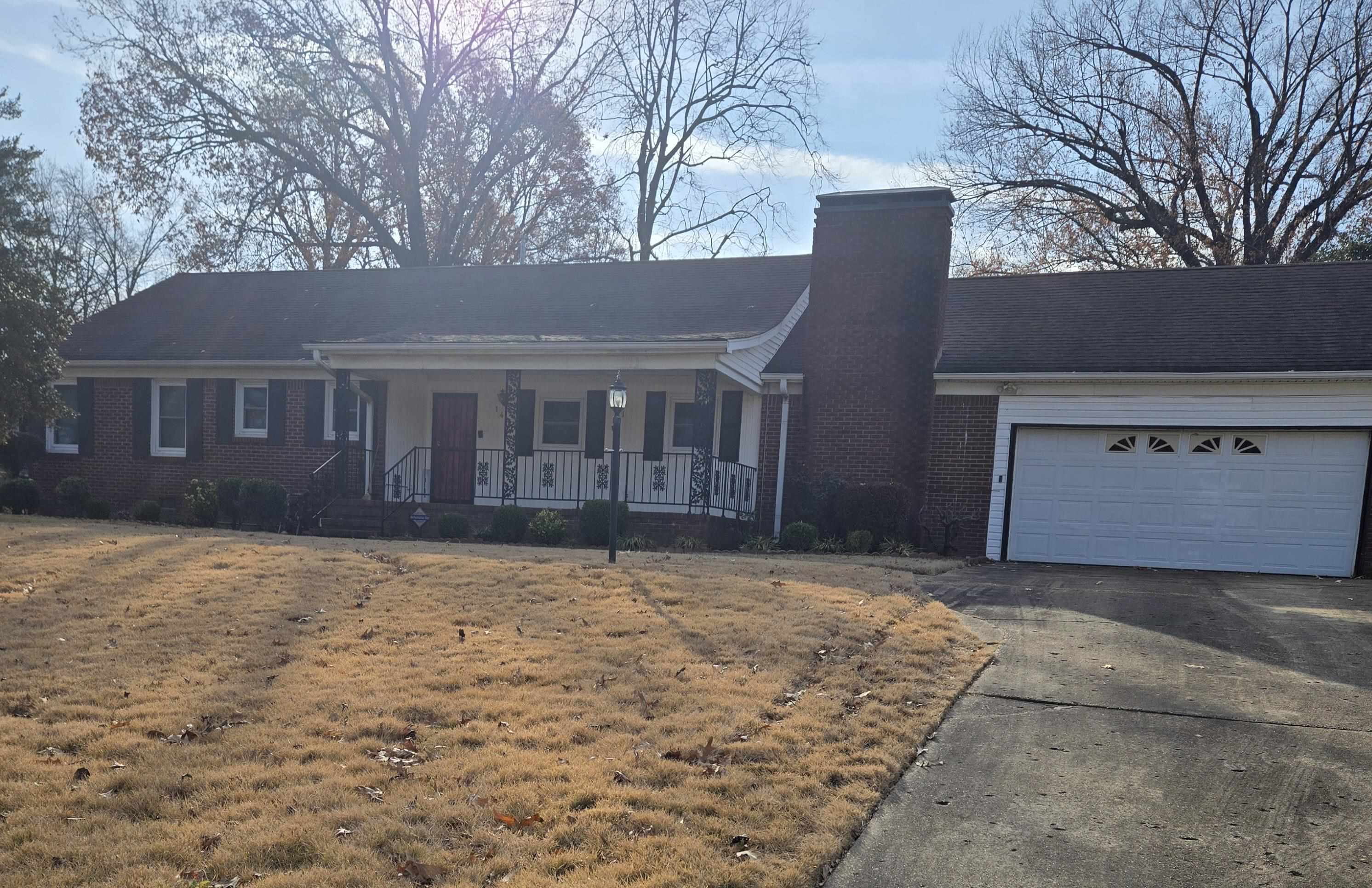 Ranch-style home with a porch and a garage