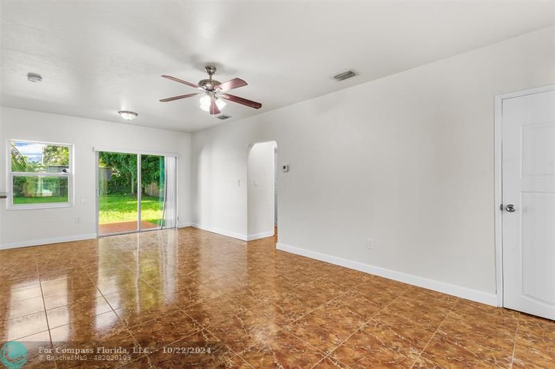 an empty room with windows and ceiling fan