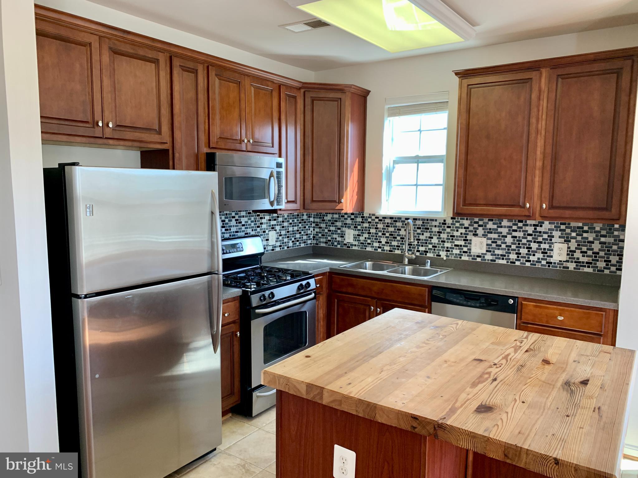 a kitchen with granite countertop a refrigerator and a sink