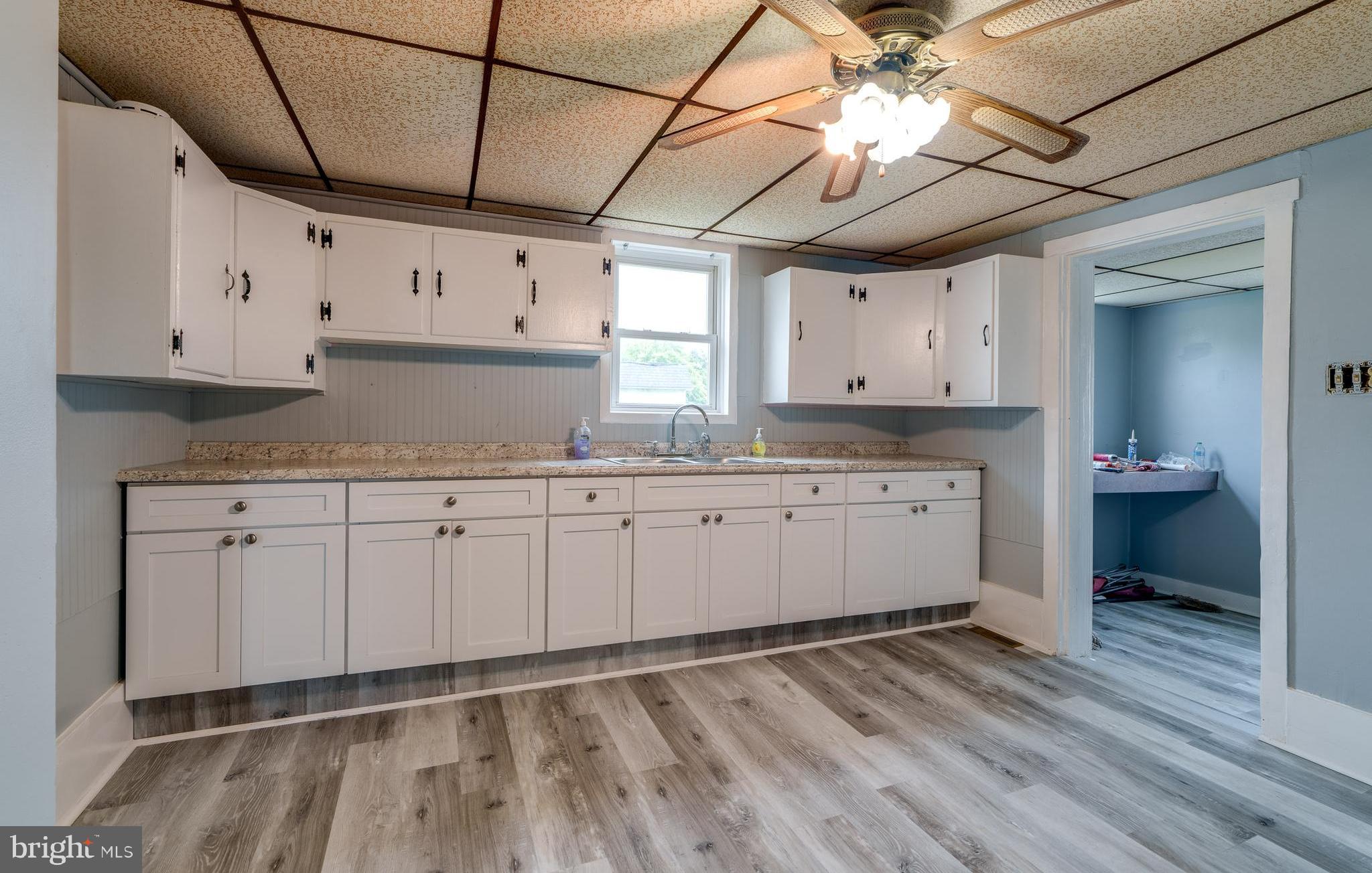 a kitchen with granite countertop a sink window and cabinets