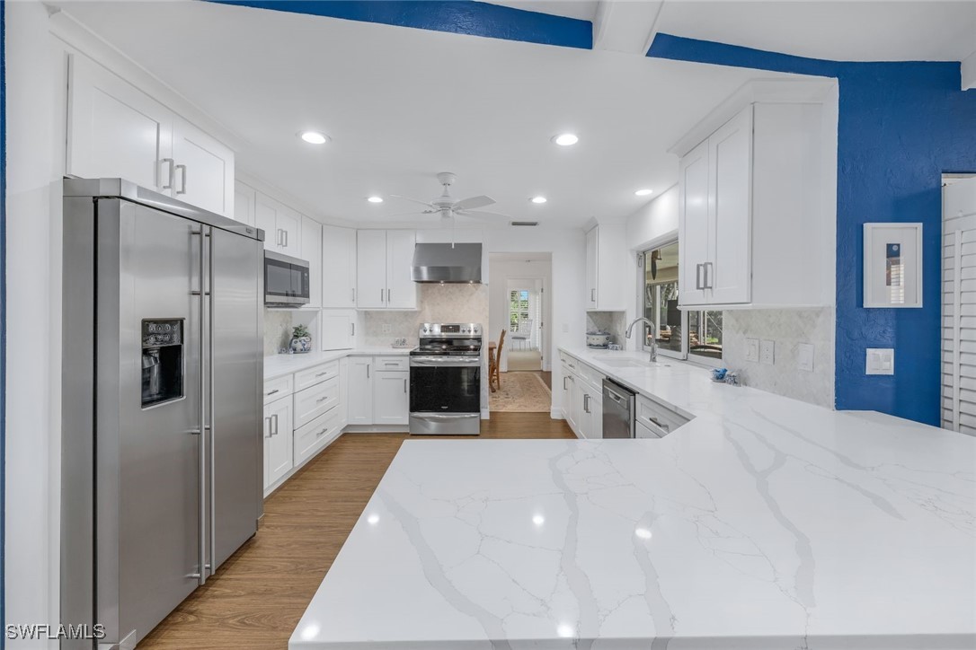 a kitchen with stainless steel appliances kitchen island a sink and refrigerator