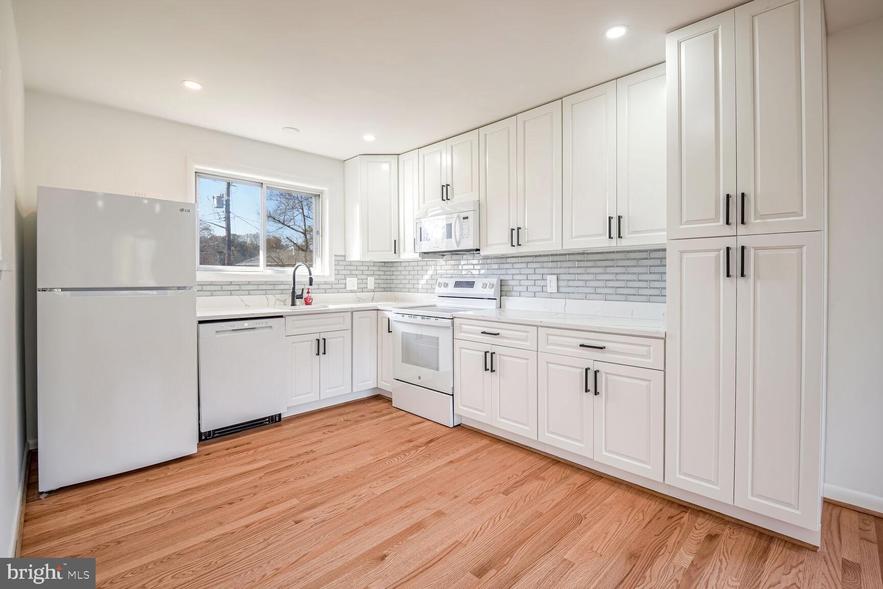 a kitchen with white cabinets and white appliances