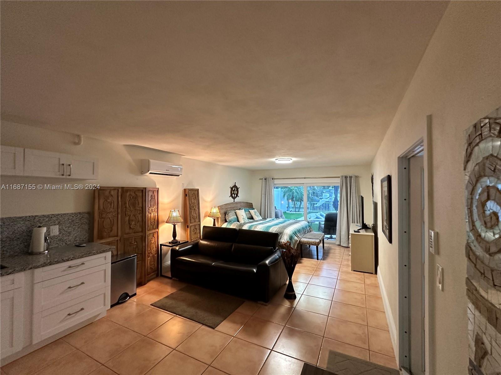 a large kitchen with cabinets and living room view