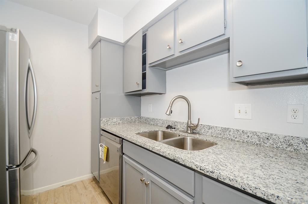 a kitchen with granite countertop a sink and cabinets