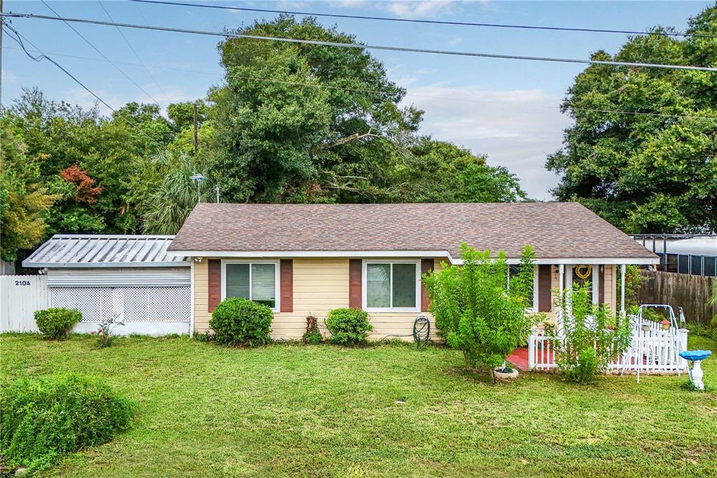 a front view of a house with a yard and potted plants