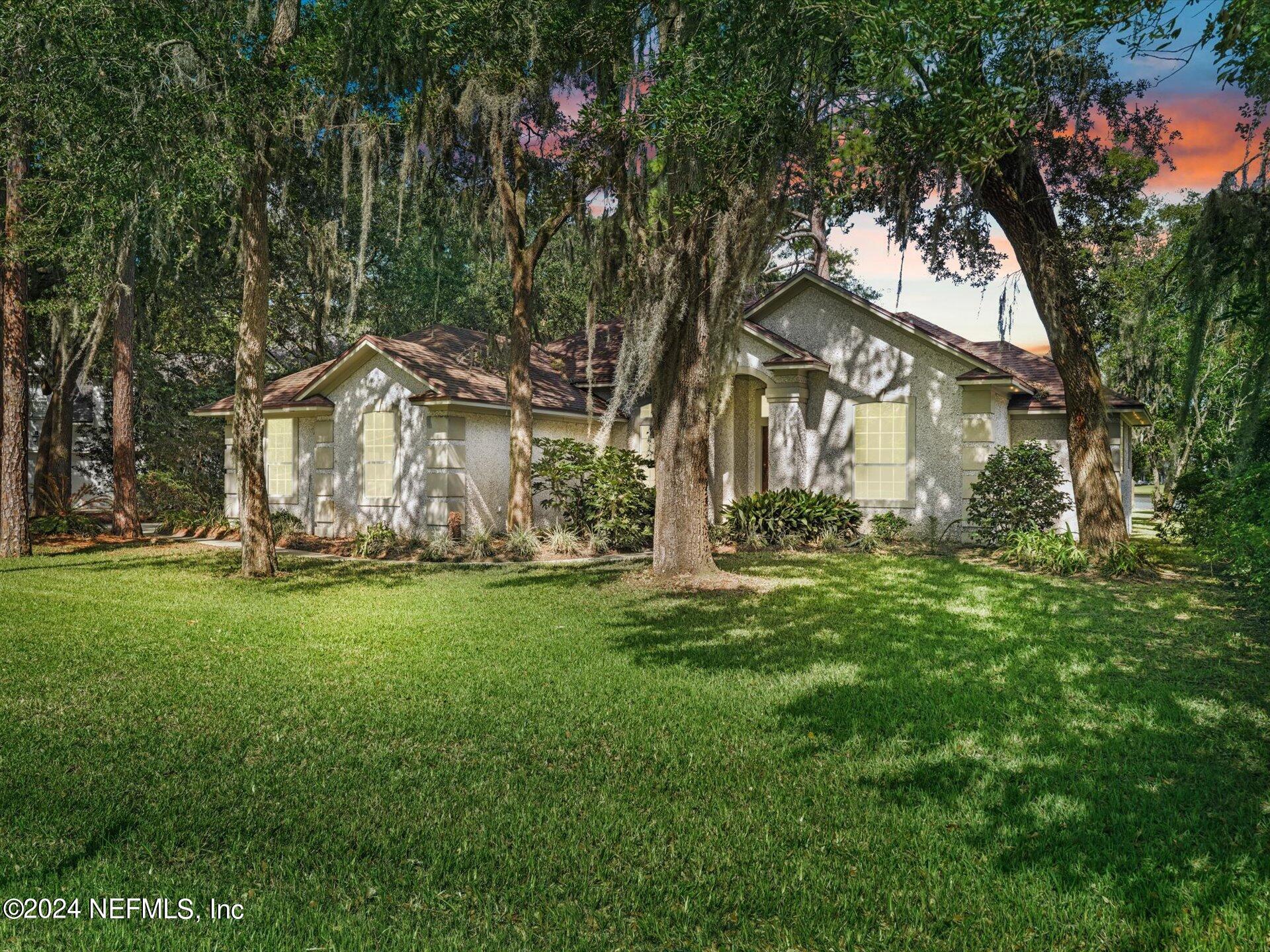 a view of backyard of house with green space