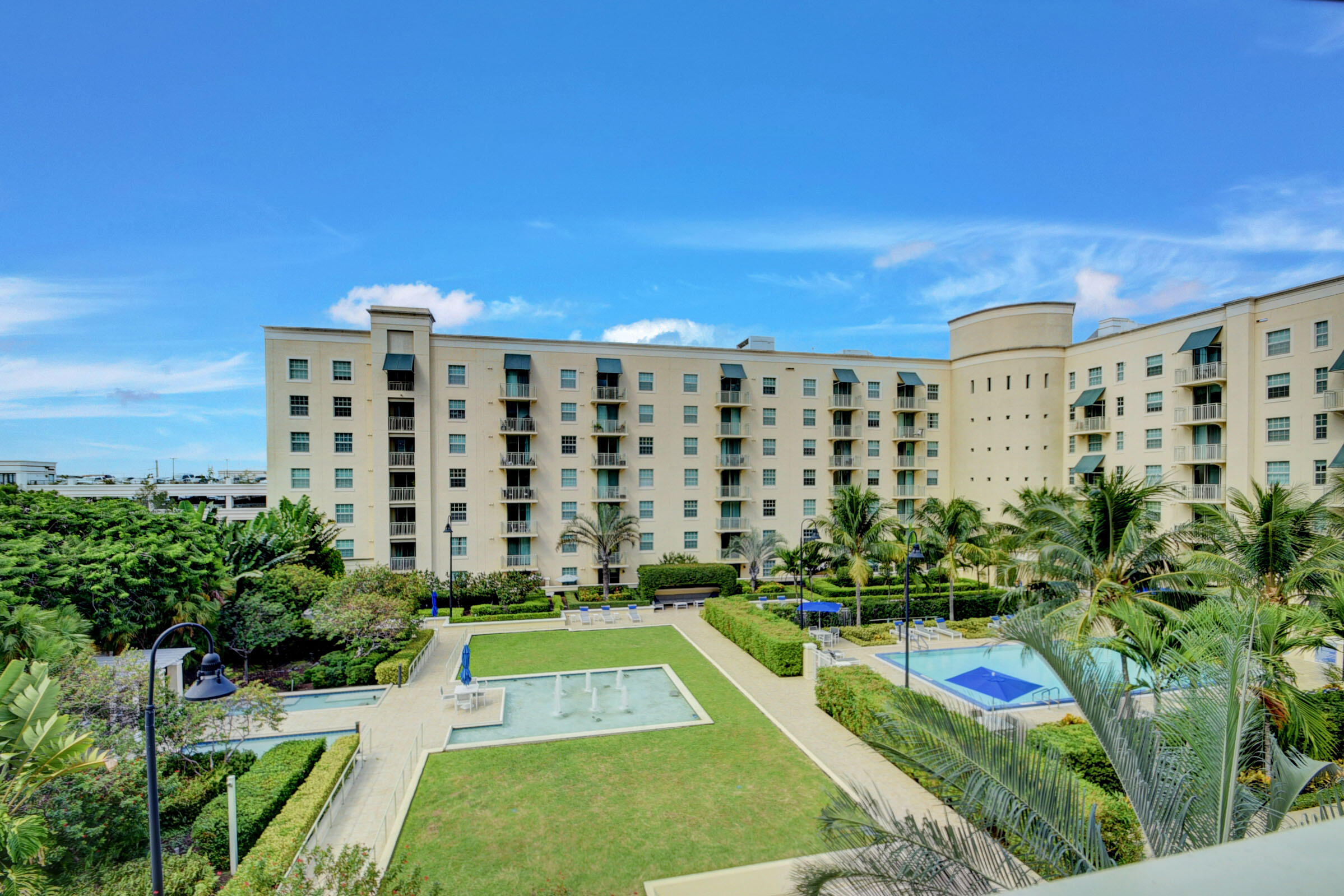 a view of a multi story residential apartment building with a yard