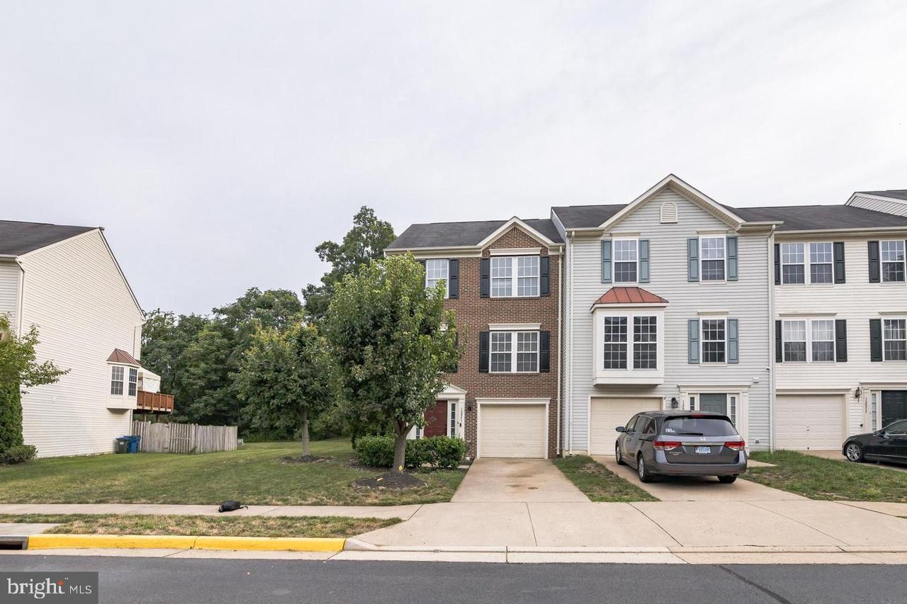 a front view of a house with a garden and parking space