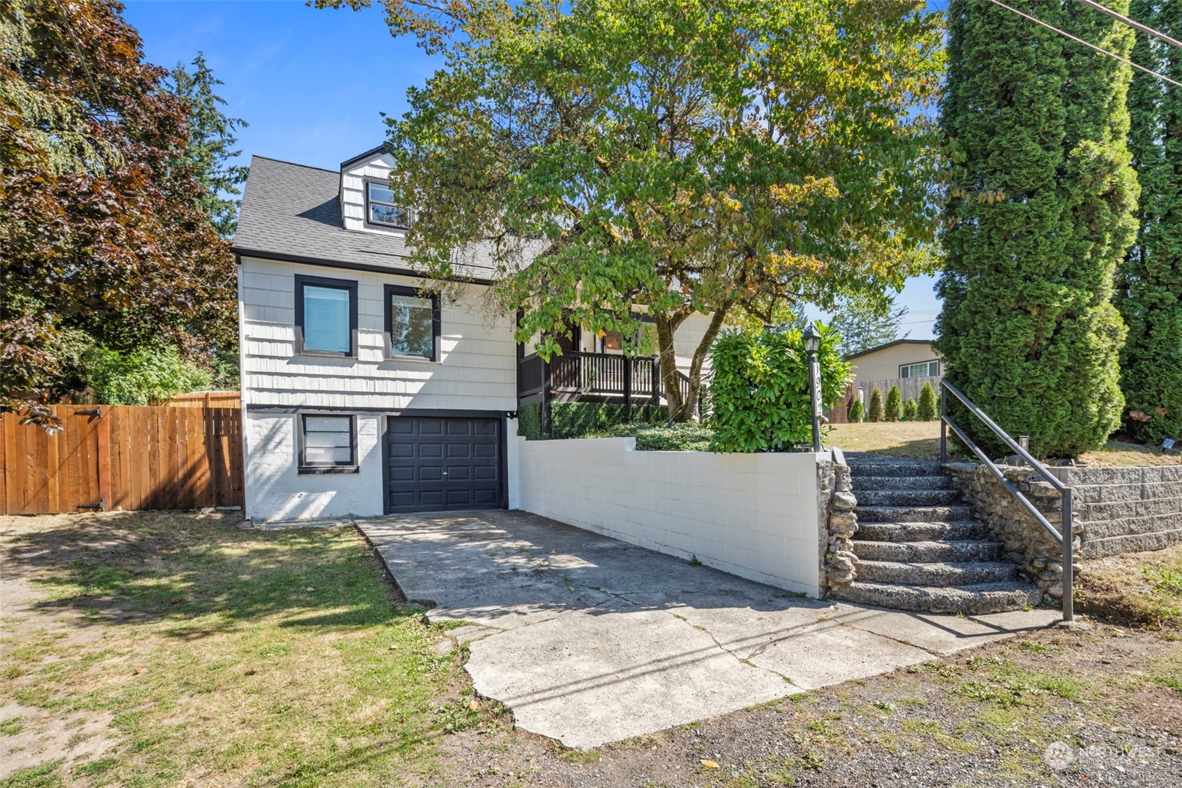 a view of a house with a yard and large tree