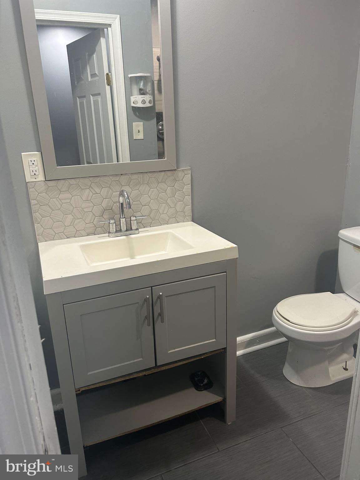 a bathroom with a toilet sink and mirror