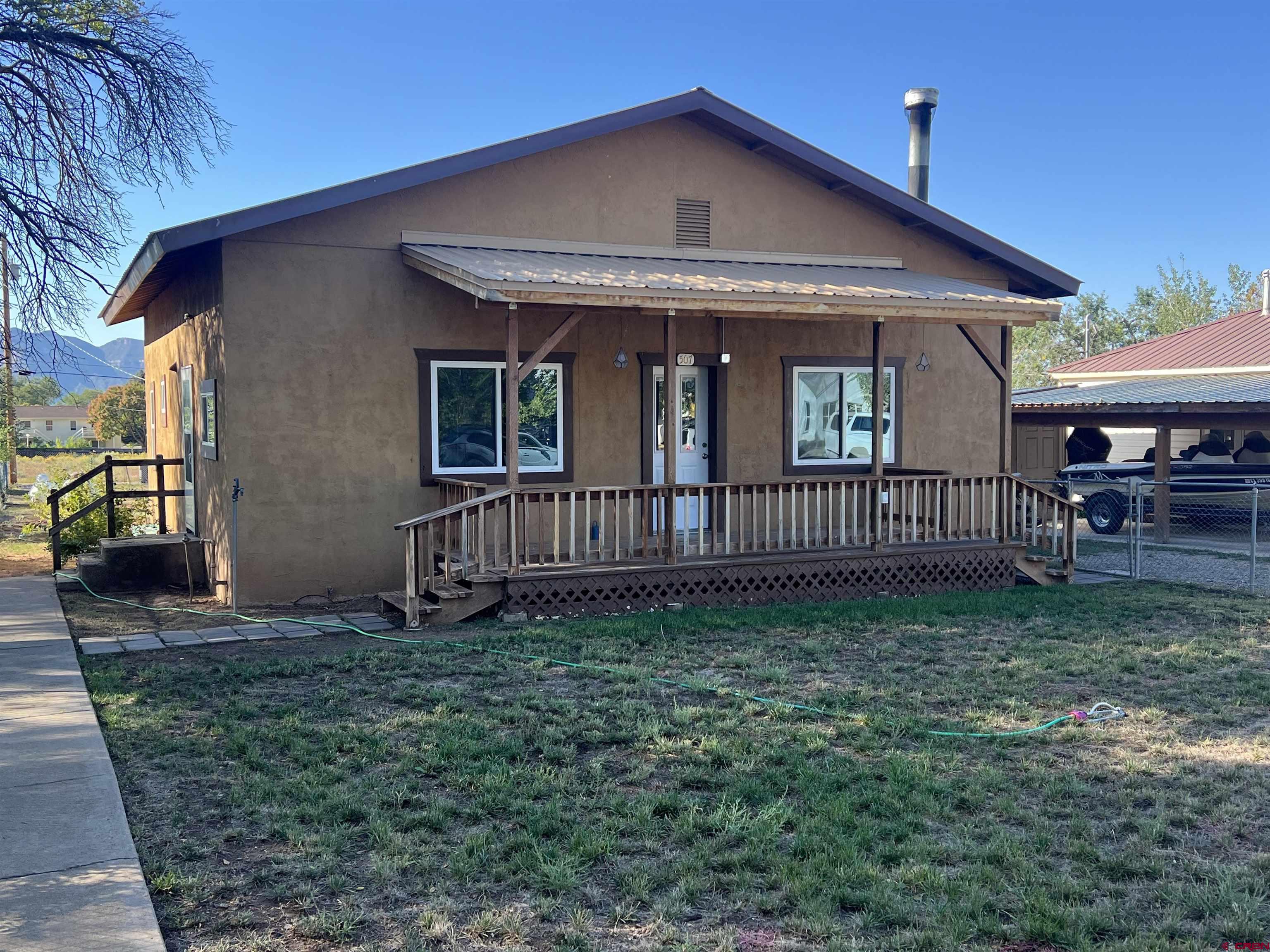 a view of a house with a yard and deck